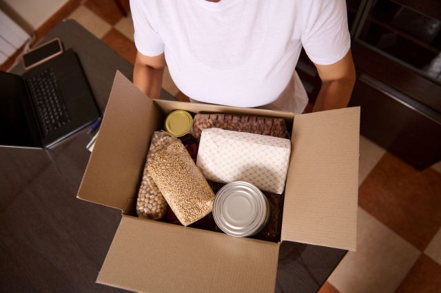 A person holding a box of shelf-stable food.