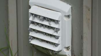 A vent covered in dust and lint.