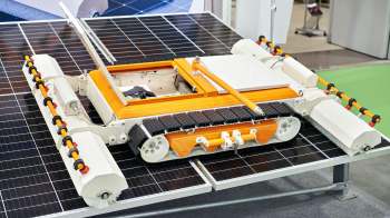 A robotic device designed for cleaning solar panels, positioned on a solar panel surface.