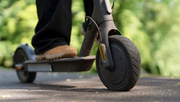 A person standing on an electric scooter.