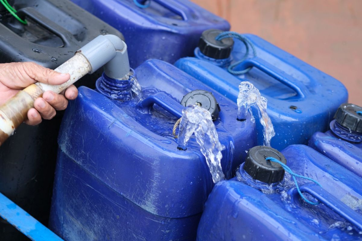 A person filling water containers.