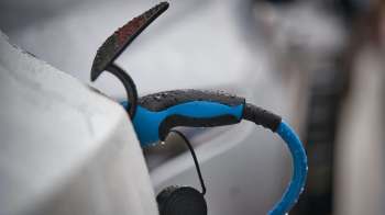 An electric vehicle charging in the rain.