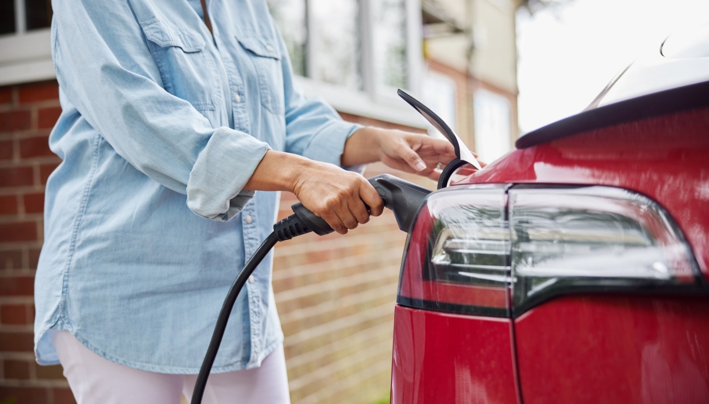 A person charging an EV.