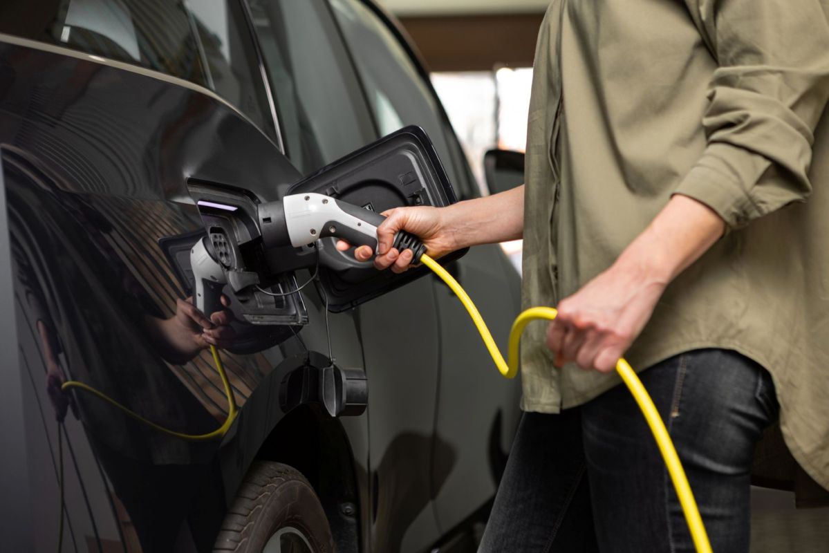 A person plugging in an EV charger.