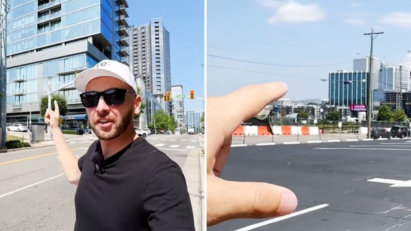 A person points towards a building in an urban setting, with construction and vehicles in the background.