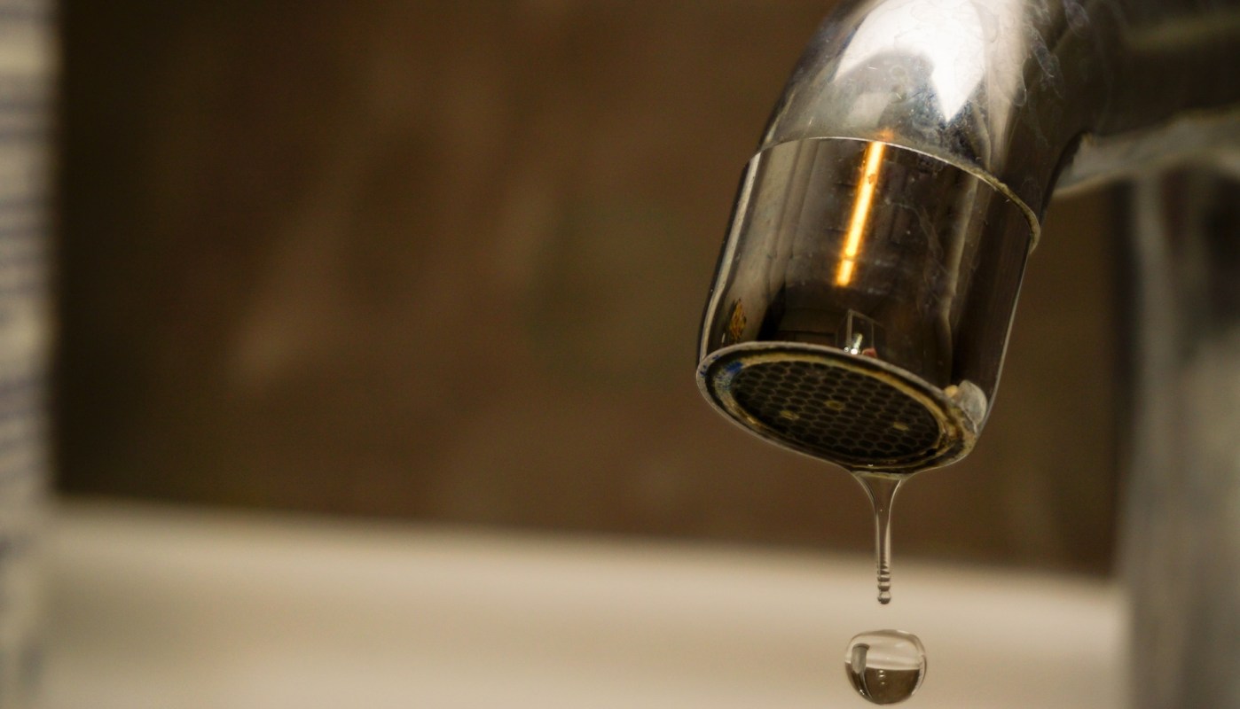 A faucet dripping water in a bathroom setting.