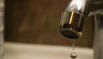 A faucet dripping water in a bathroom setting.
