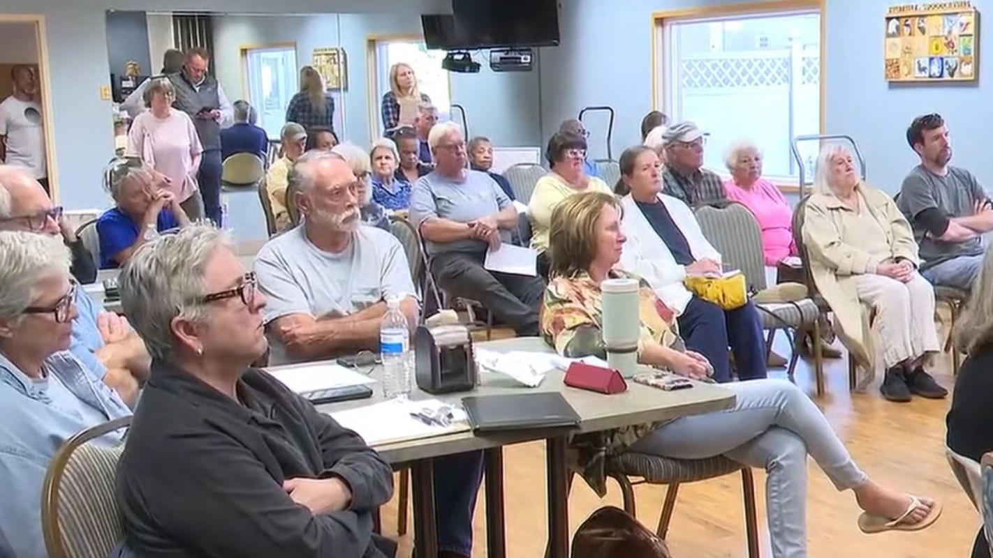 A group of people seated in a community room.