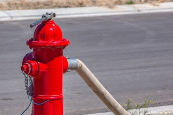 A hose attached to a red fire hydrant.