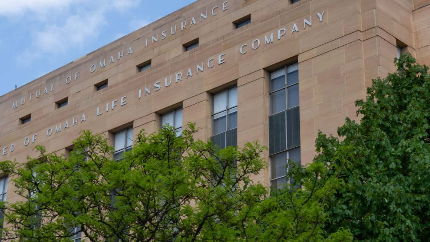 A building with signage for Mutual of Omaha Insurance and greenery at the base.
