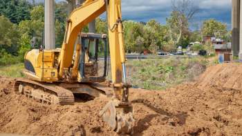 An excavator digging at a construction site.