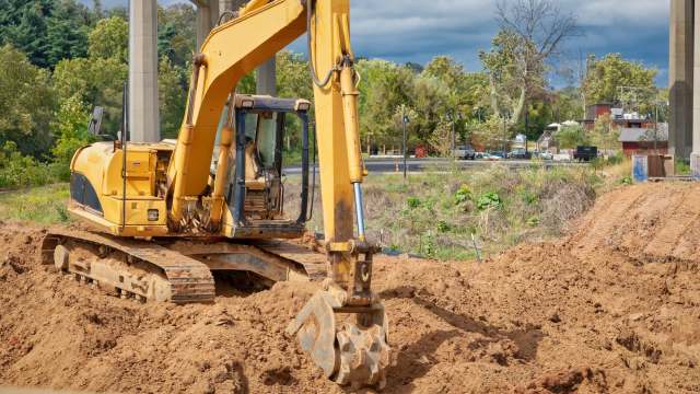 An excavator digging at a construction site.