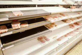 A sparsely stocked meat section in a grocery store.