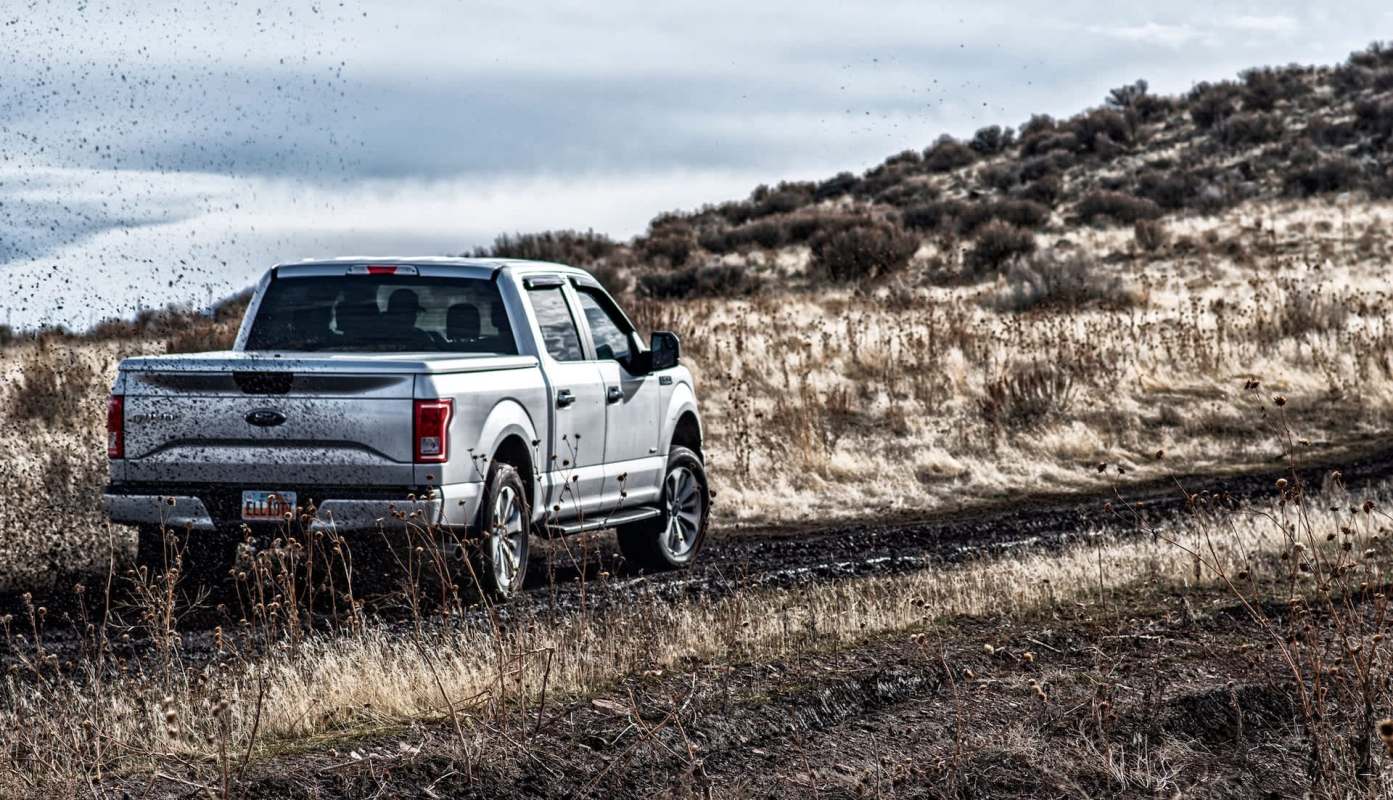 A pickup truck navigating a muddy path.