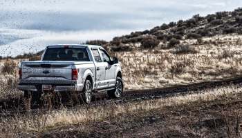 A pickup truck navigating a muddy path.