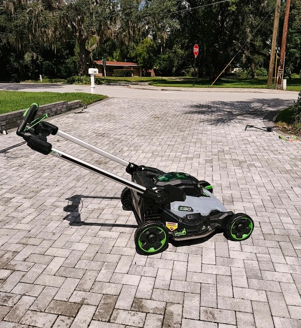 An electric EGO lawn mower on a interlocking brick driveway.