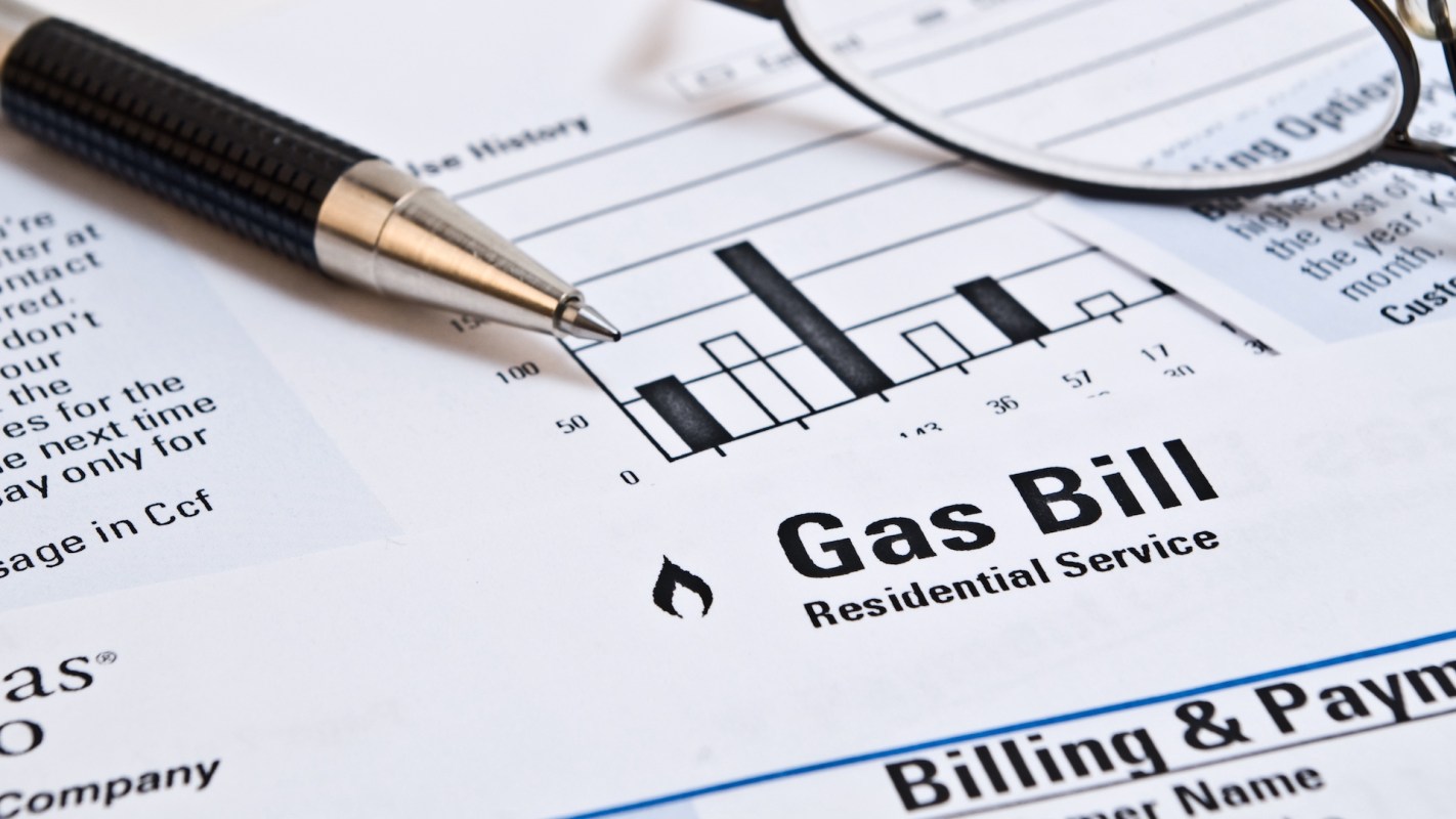 A gas bill document with a usage history graph and a pen placed beside it.