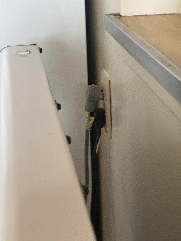 A power outlet with two cables plugged into it.