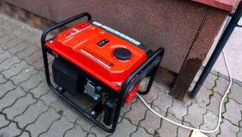 A red generator next to a wall.
