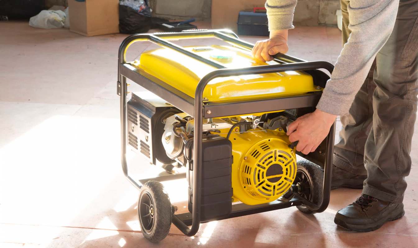 A person operates a yellow generator in a workspace.