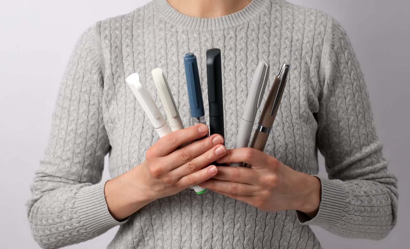 A person holding injection pens.