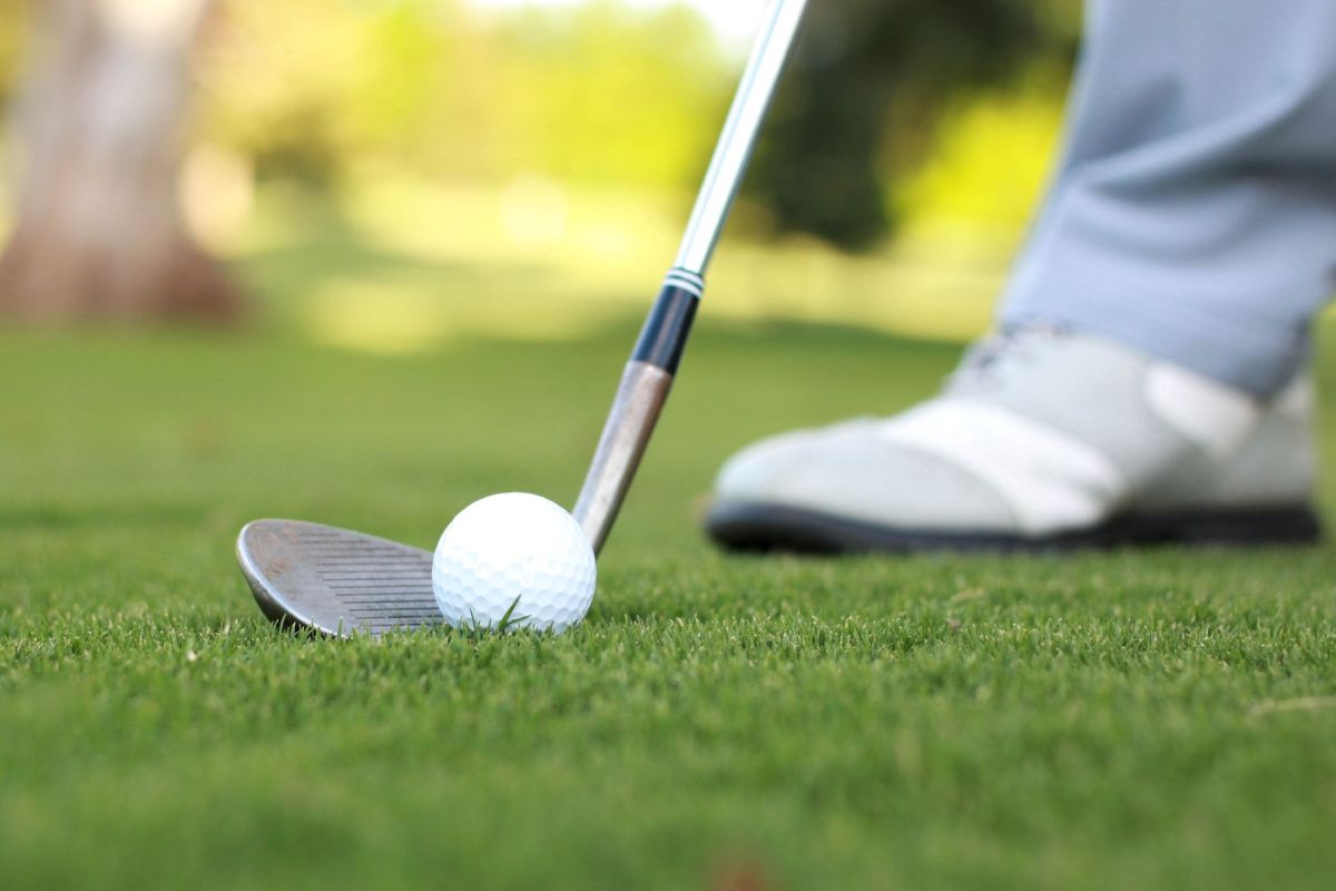 A person striking a golf ball.