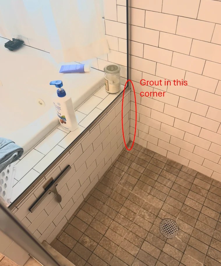 Cracked grout in a shower corner. 