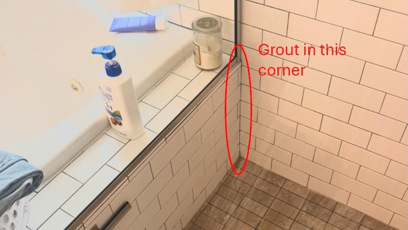 Cracked grout in a shower corner.