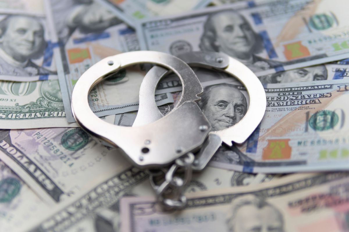 Handcuffs on top of hundred dollar bills.