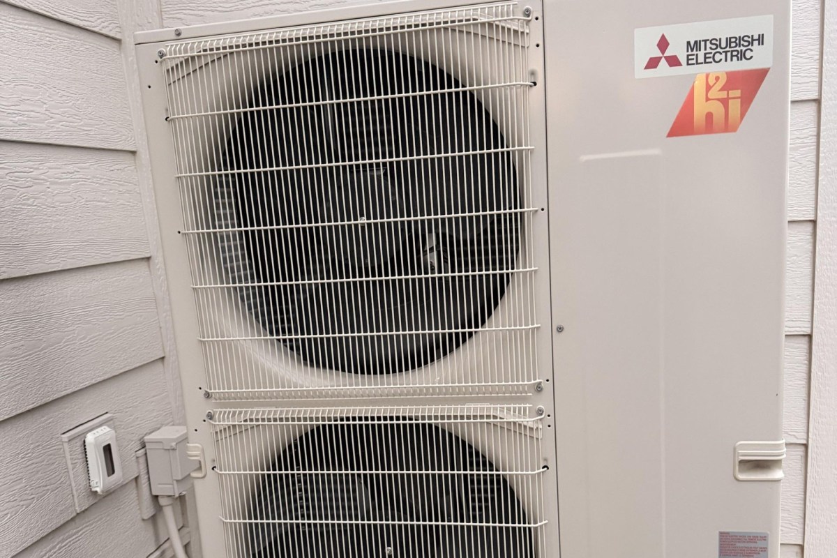 An outdoor air conditioning unit mounted against a wall.