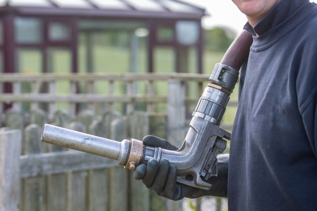 A man carrying a heating oil pipe.