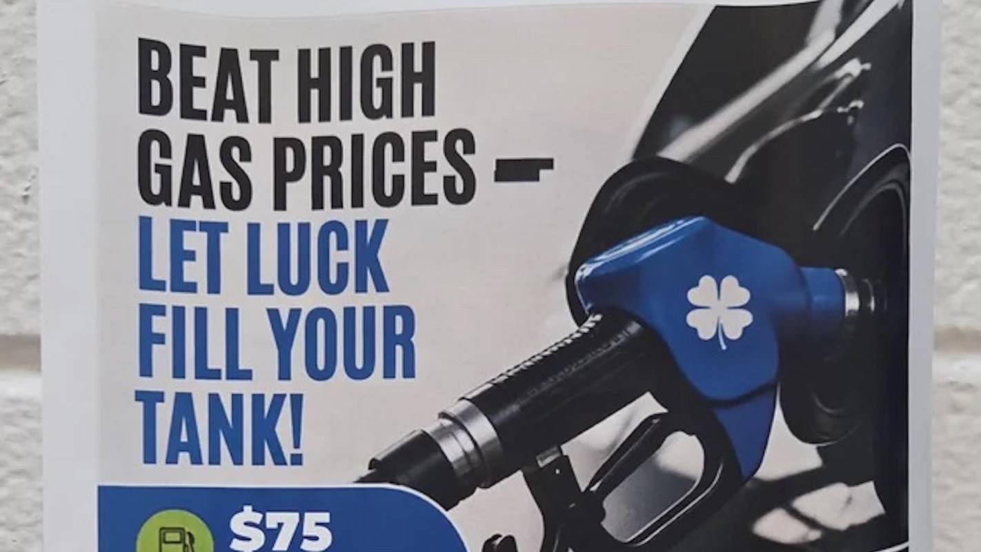A sign promoting a gas price discount with a gas pump handle and the text "Beat high gas prices - let luck fill your tank!"