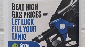 A sign promoting a gas price discount with a gas pump handle and the text "Beat high gas prices - let luck fill your tank!"