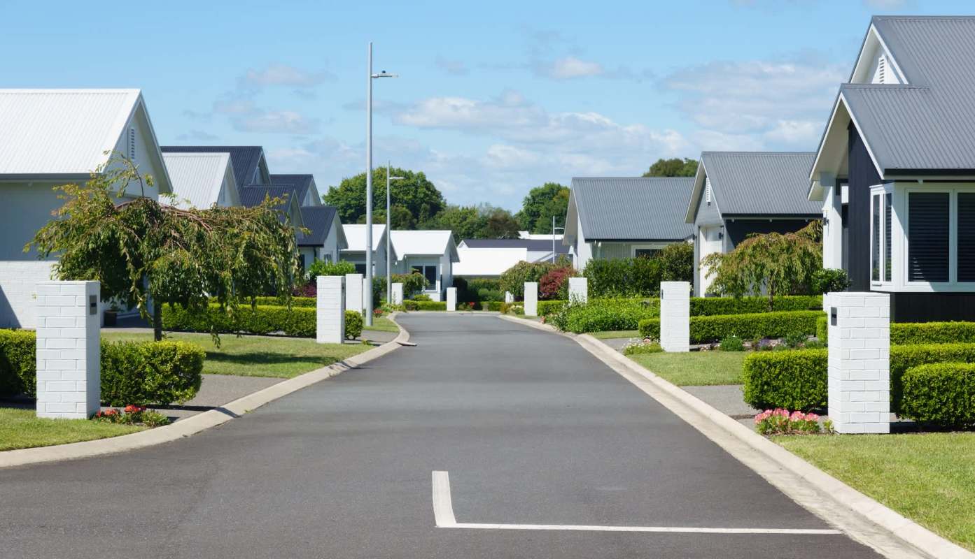 A quiet residential street with manicured hedges.