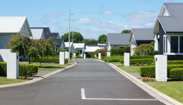 A quiet residential street with manicured hedges.