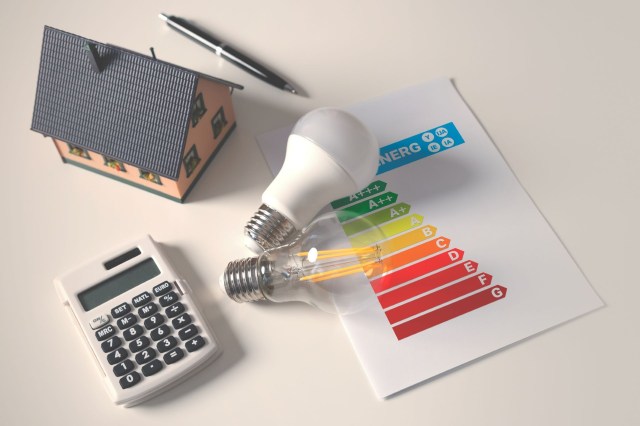 An energy-efficiency concept next to a small model house and calculator.