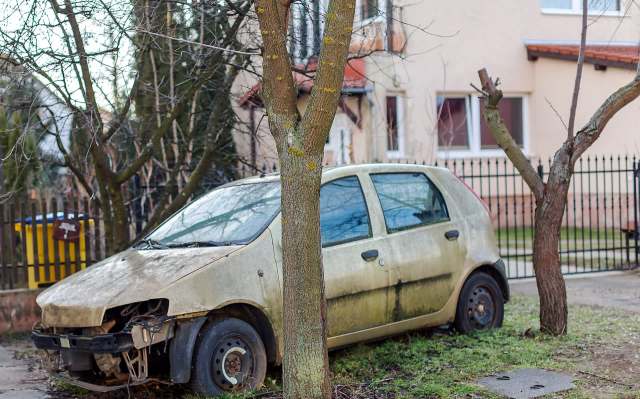 A broken-down car in a yard.