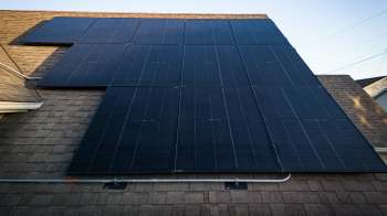 Solar panels installed on a sloped roof with shingles.