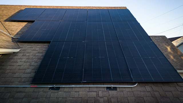 Solar panels installed on a sloped roof with shingles.