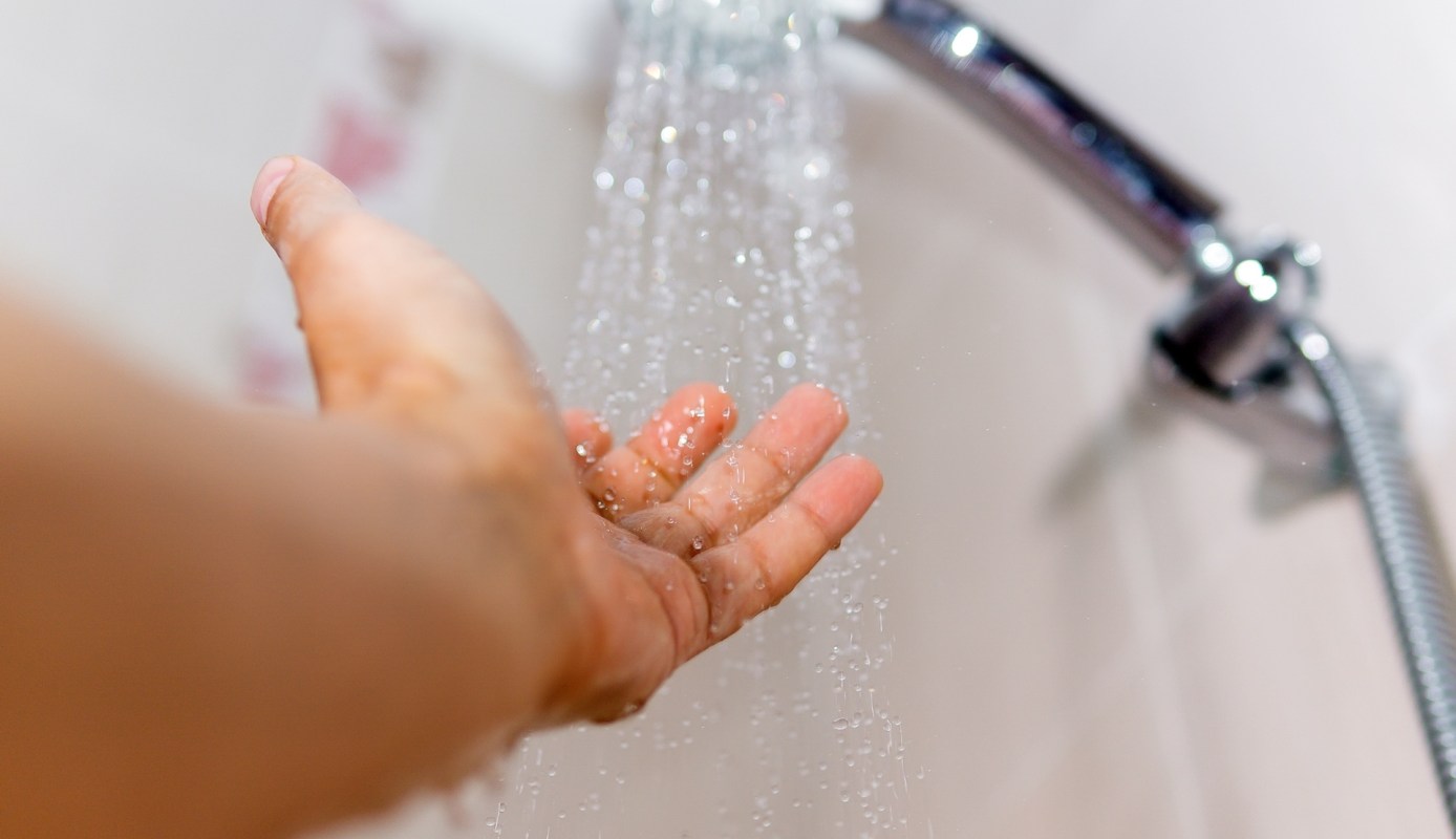 A hand under a running shower.