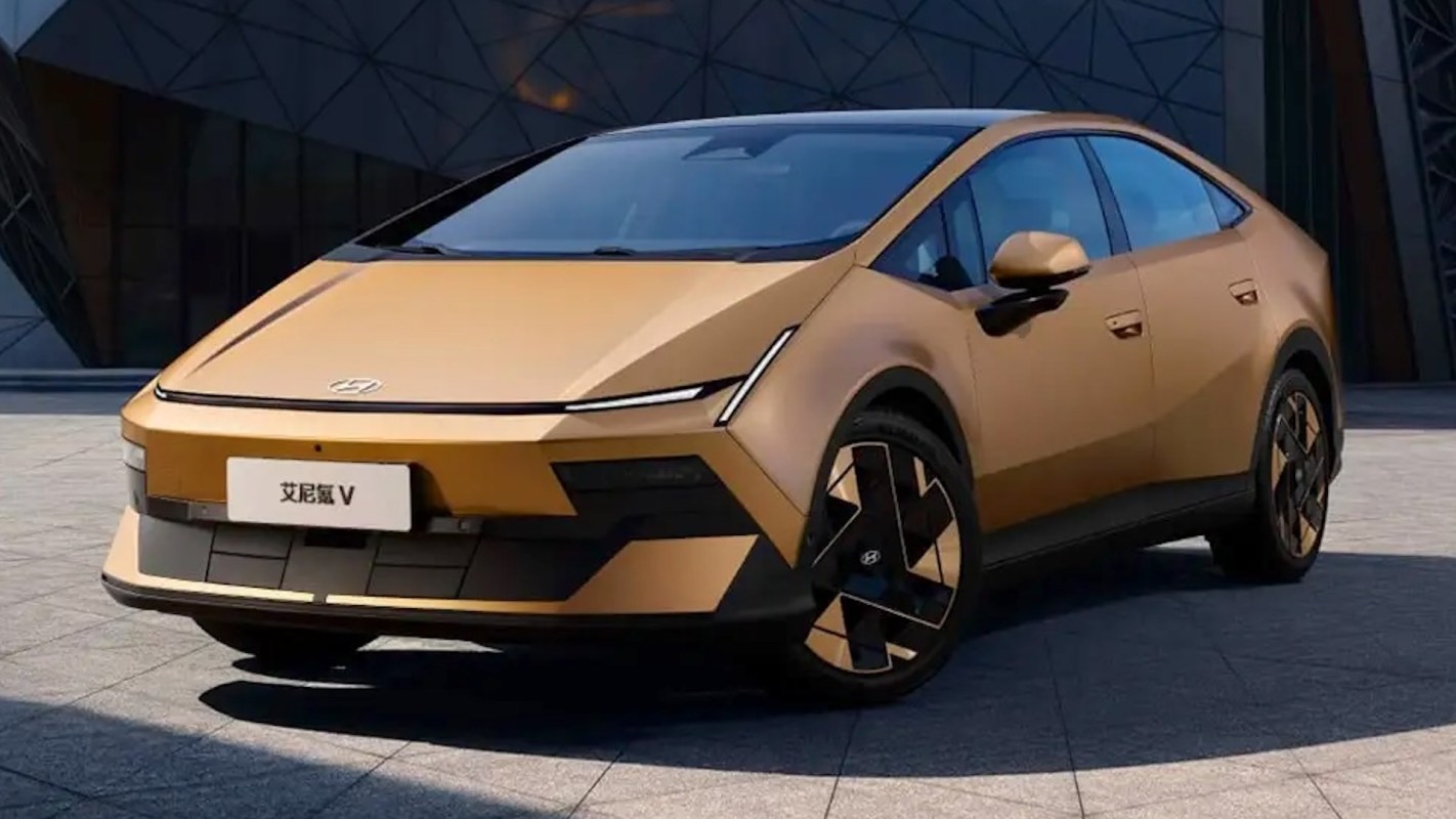 A modern Hyundai electric car in a shiny gold finish parked on a pavement.