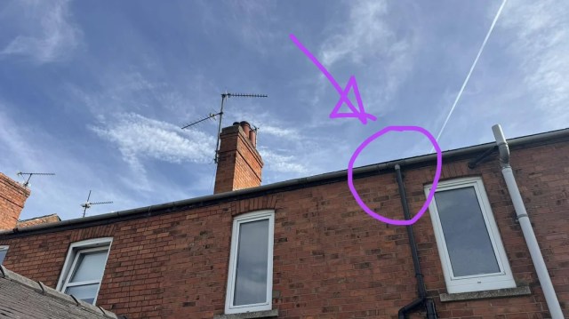 A pipe running down a brick house.