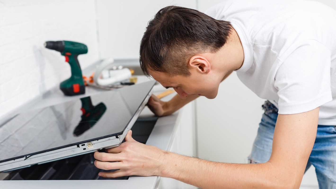 A person installing an induction stove.