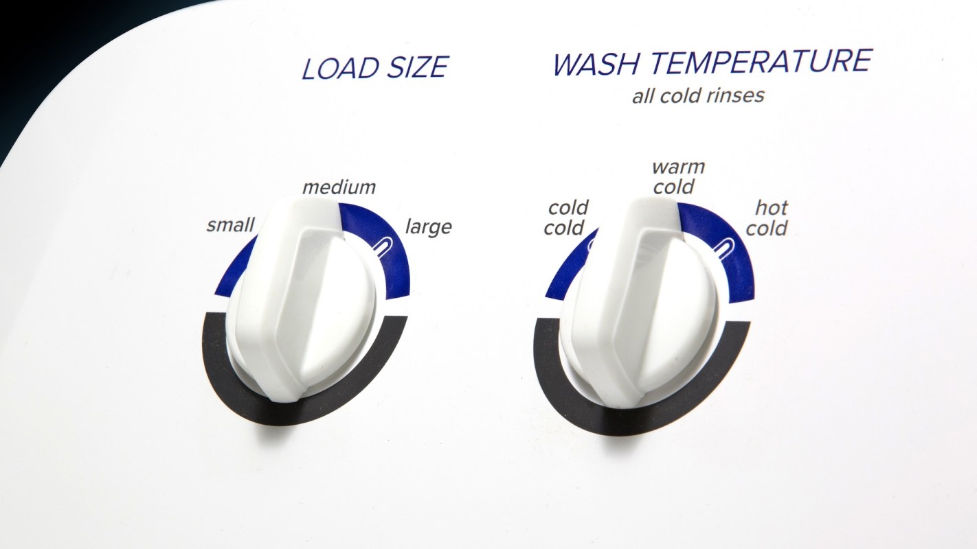 A washing machine control panel with dials for load size and wash temperature settings.