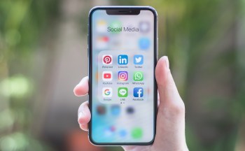 A person holds an iPhone X smartphone.