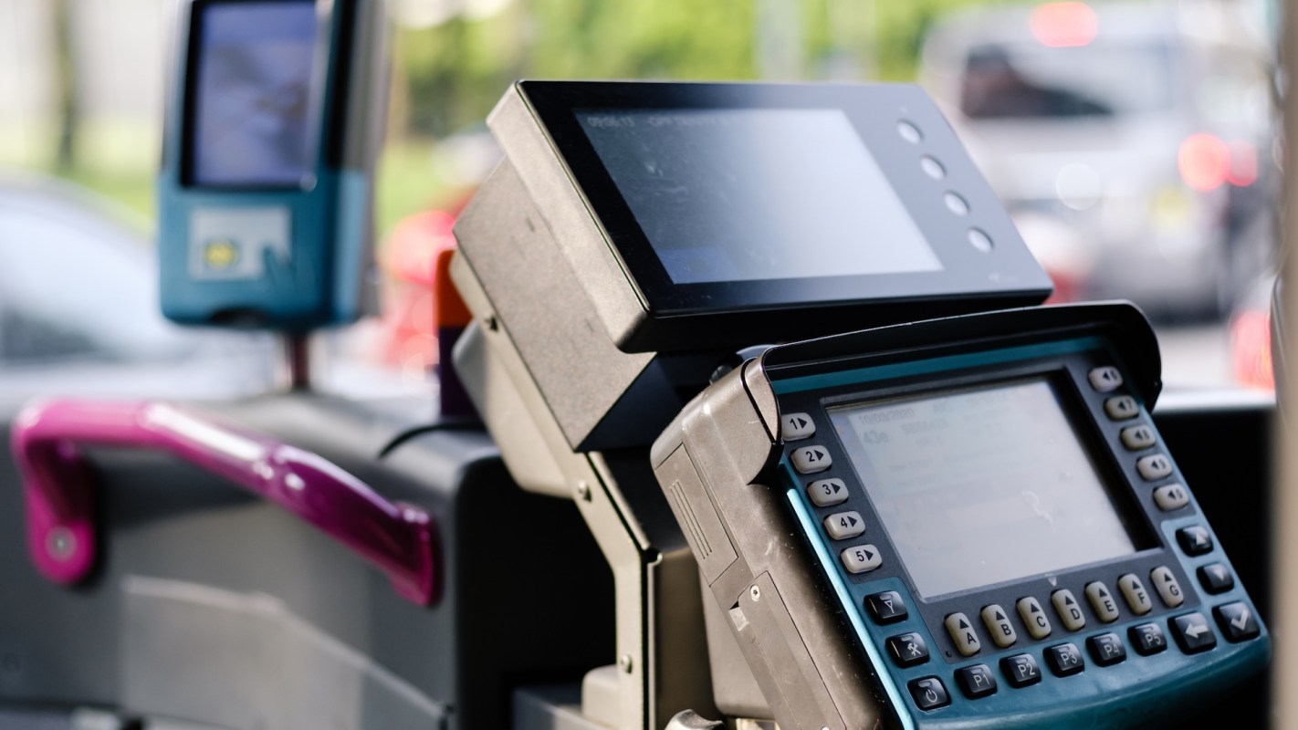 Bus fare payment machines with digital displays and keypad controls.