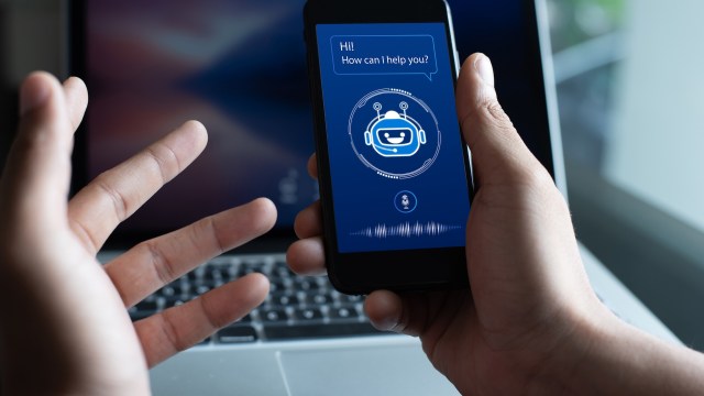 A person interacts with a smartphone displaying a chatbot interface.