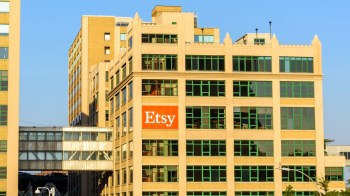 A building with large green windows and an orange Etsy sign on the facade.