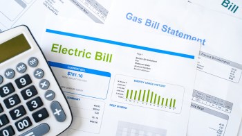 A calculator beside electric and gas bills.