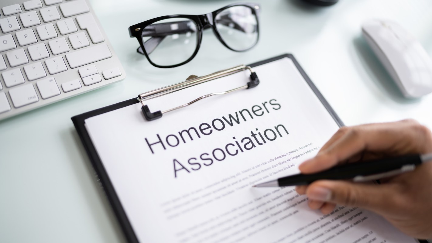 A document labeled "Homeowners Association" next to glasses and a computer keyboard.